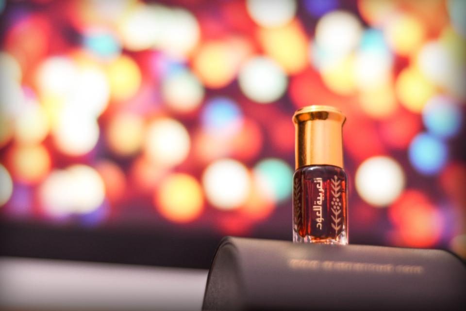 Flacon de parfum oriental en verre ambré sur fond de lumières