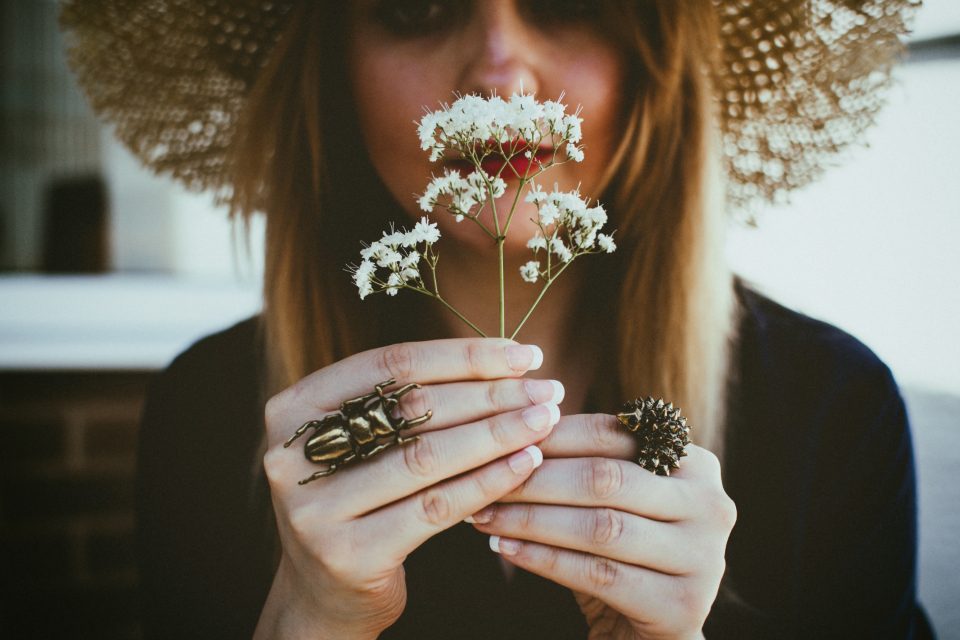 Femme respirant un petit bouquet de fleurs