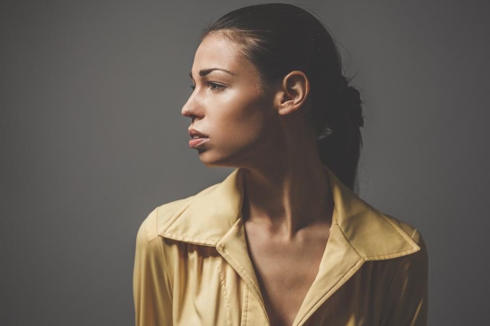 Femme de profil, le cou étant un point idéal pour appliquer son parfum